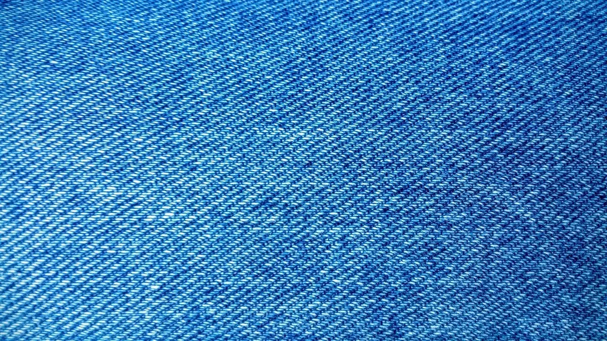 A close-up view of a piece of blue denim fabric.