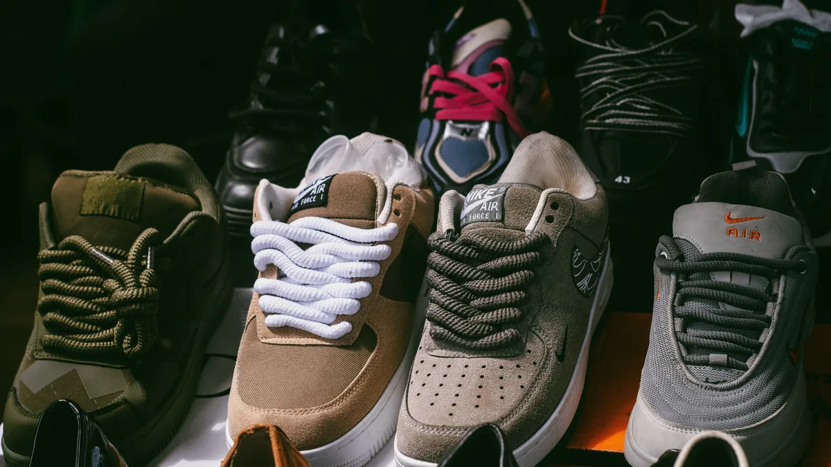 A collection of sneakers arranged in a row, with the toes facing the camera.